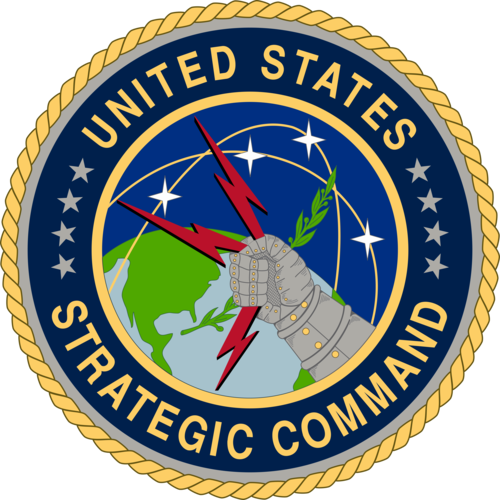 US Strategic Command emblem. Features an armoured fist holding three red lightning bolts and an olive branch, superimposed over a globe along with ICBM flight paths and stars.