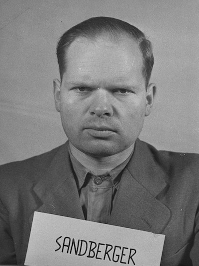 Martin Sandberger holding a sign that says "SANDBERGER".