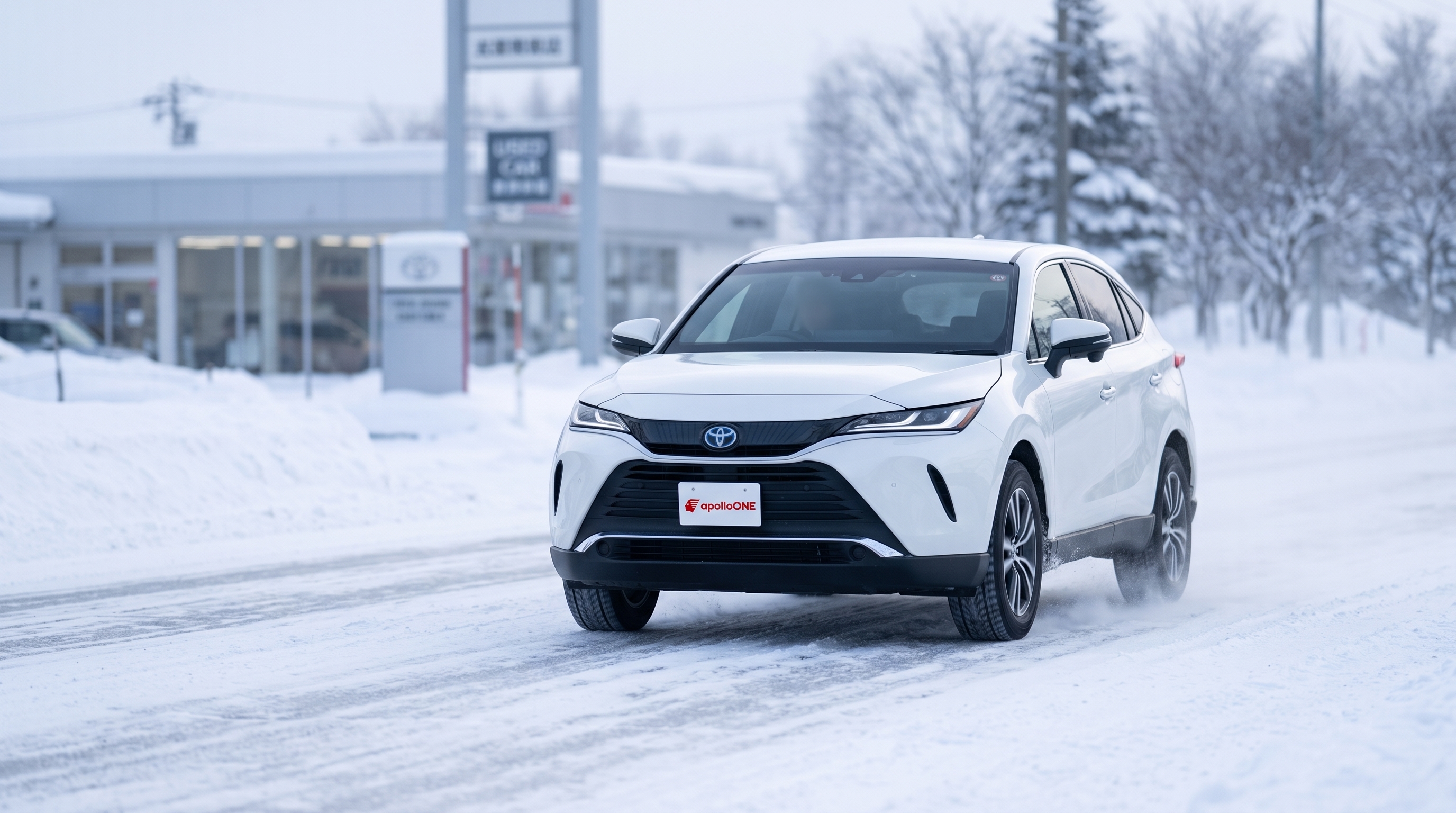 冬の凍てつく朝、雪化粧をした木々を背景に、雪が積もった路面を力強く走行する白いSUVの様子。雪道での安定した走行性能と安心感が伝わる風景写真。