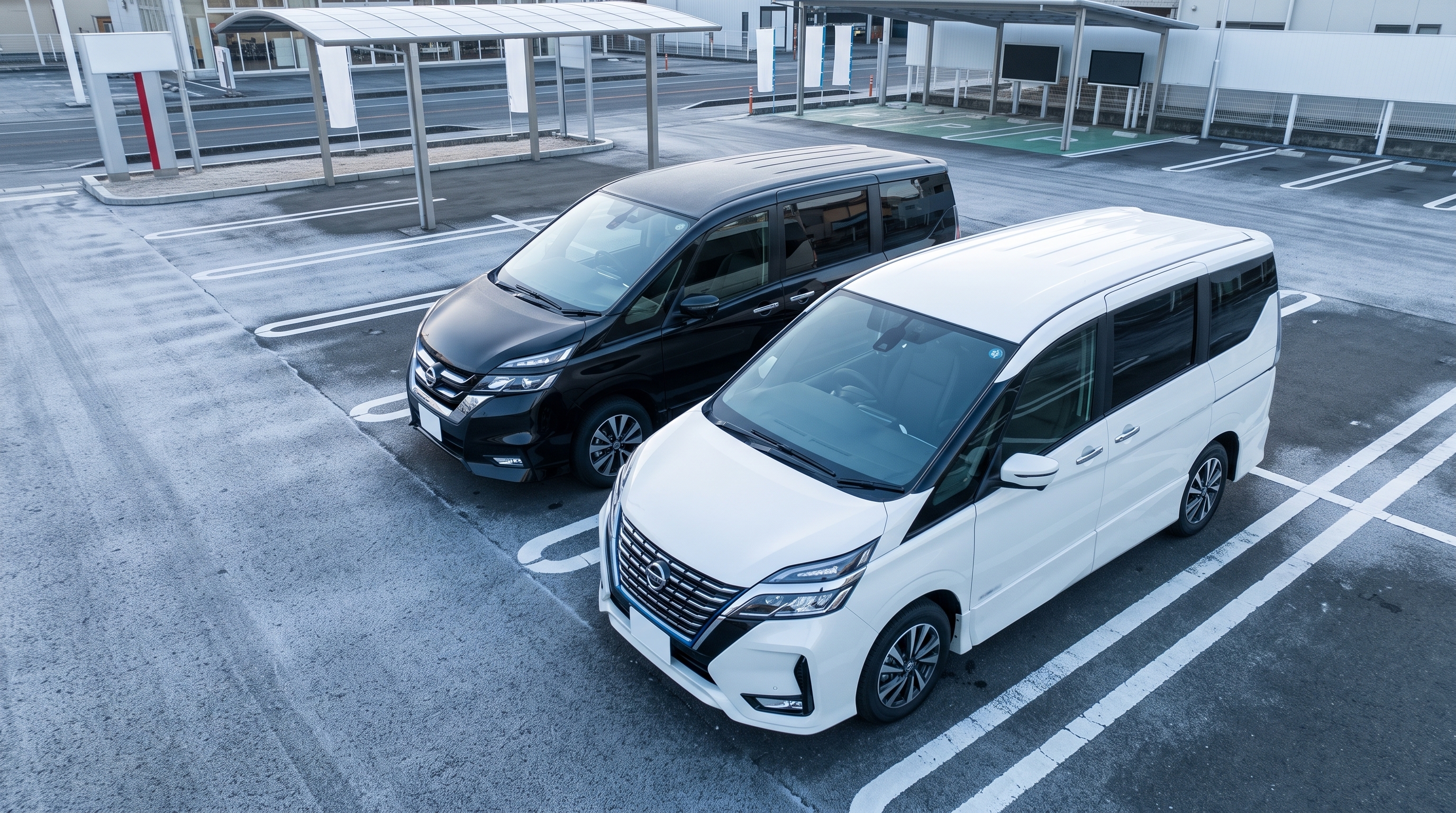 冬の澄んだ朝の空気の中、中古車展示場に並べられたパールホワイトの新型ミニバンとブラックの旧型ミニバンを斜め上から見下ろし、デザインの違いを対比した様子。