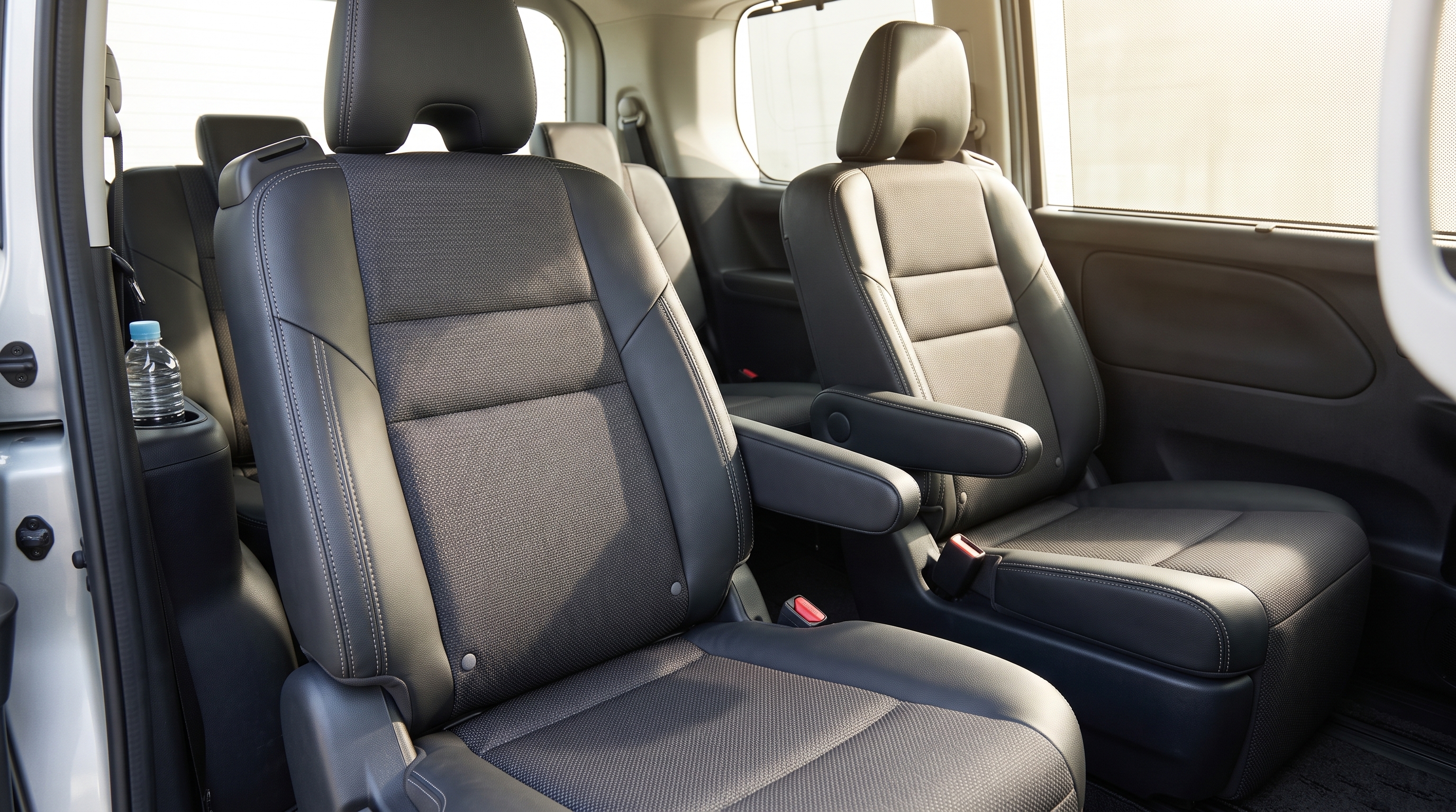 明るい日差しが差し込むミニバン車内で、セカンドシートを捉えたクローズアップ。合皮やファブリックの素材感など、上位モデルならではの内装の質感が分かる様子です。
