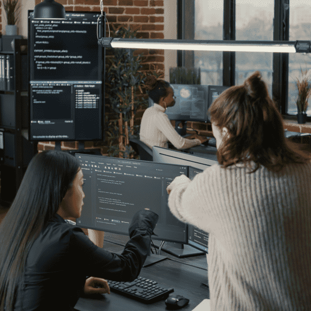 Two women collaborating in front of a computer screen, representing Appivo custom app development services working with a client.