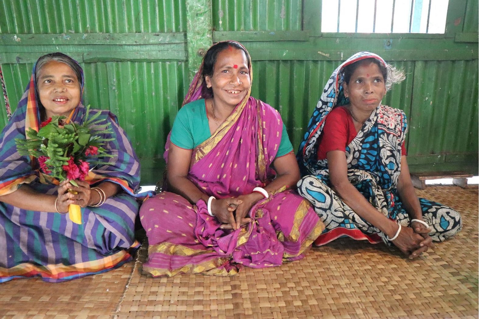 A group of women sitting on the groundDescription automatically generated with medium confidence