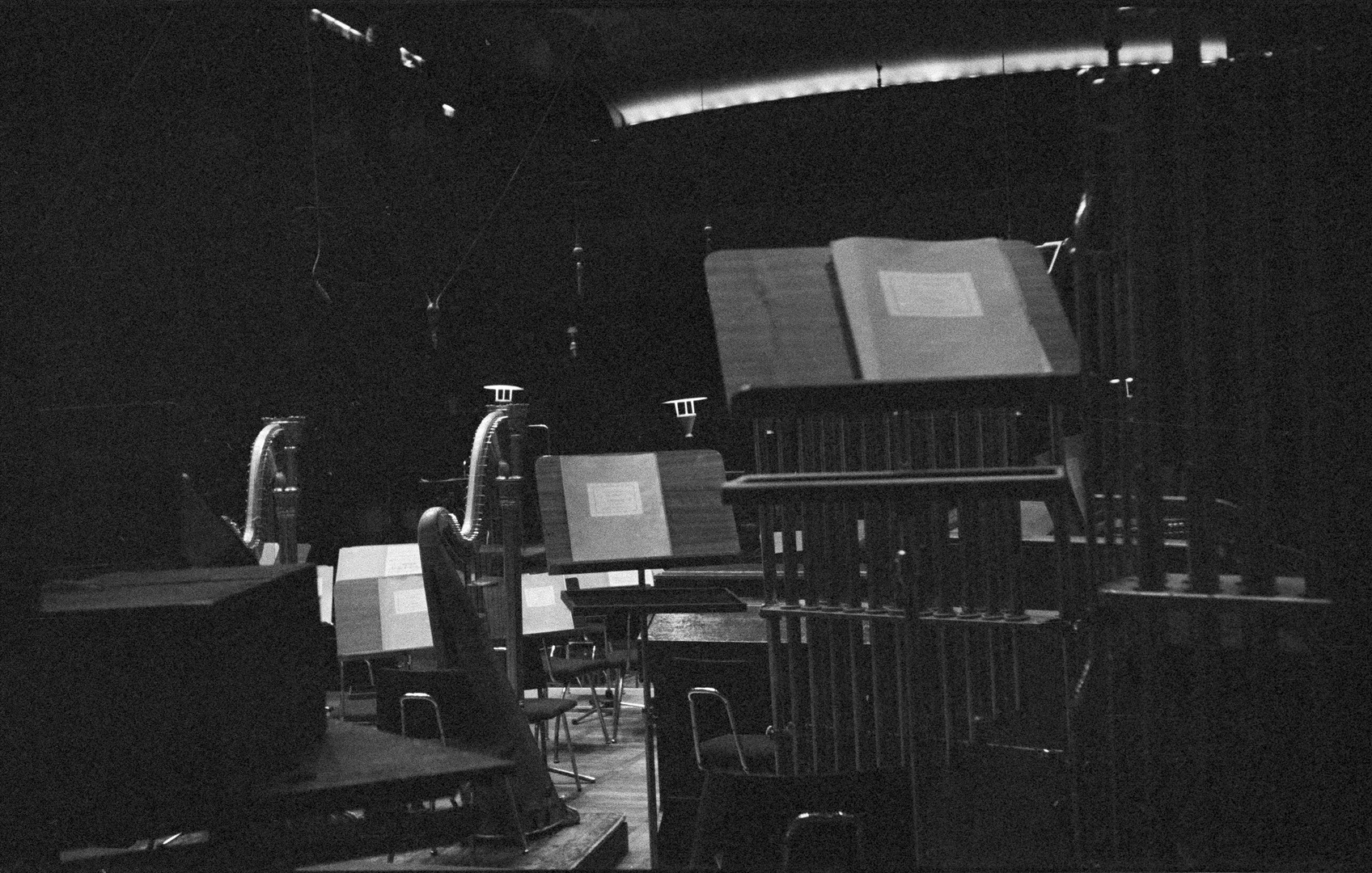 Details im Sendesaal: zwei Harfen, Glockenspiel, einige Pulte mit zugeklappten Partituren, von der Decke hängende Mikrofone 