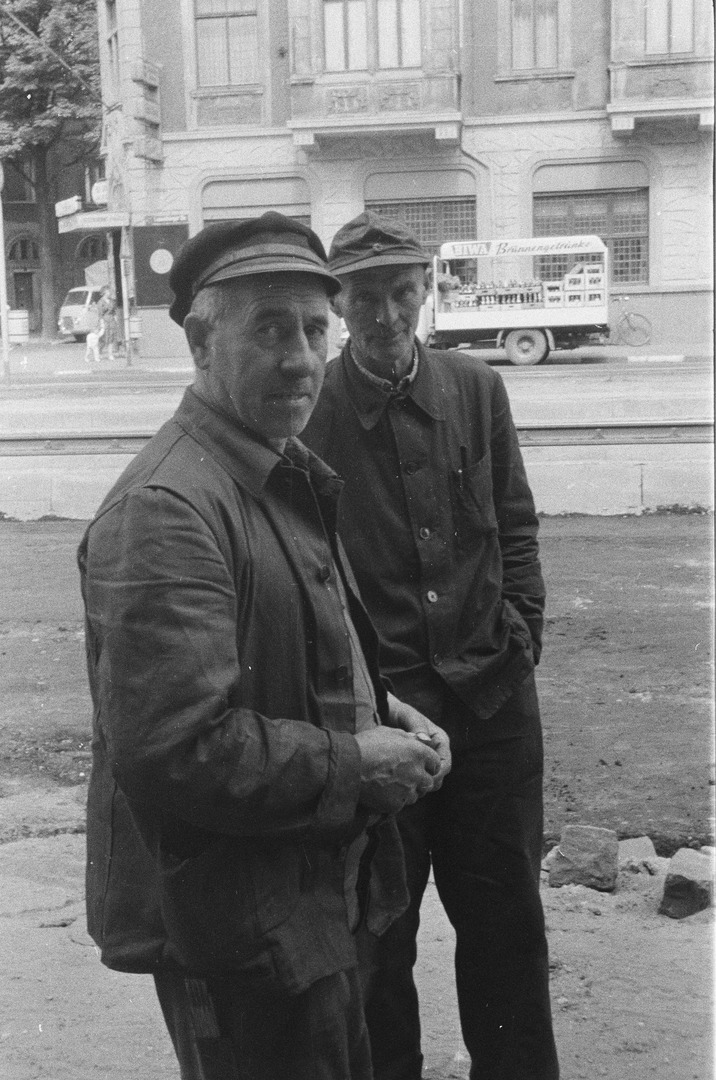 Porträt zweier Arbeiter. Im Hintergrund, auf der gegenüberliegenden Seite der Luxemburger Straße, steht ein Getränkewagen vor einer Eckkneipe. Köln 1958 oder 1959