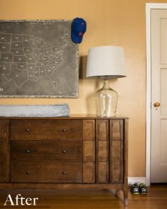 Brown dresser with clear table lamp against an orange wall