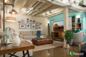 Loft-like room setting with a beige sofa, brown ottoman and polished floors