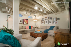 Loft like room setting with cream colored sofas and a brown wood TV stand