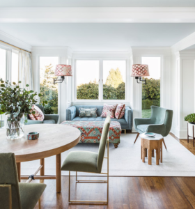 Seafoam green sofa and chair with multi colored ottoman, lamps and pillows