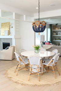 A shiny white round dining table with whit eand brown rounded back dining chairs