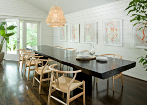 Long black rectangular dining table with tan wicker dining chairs