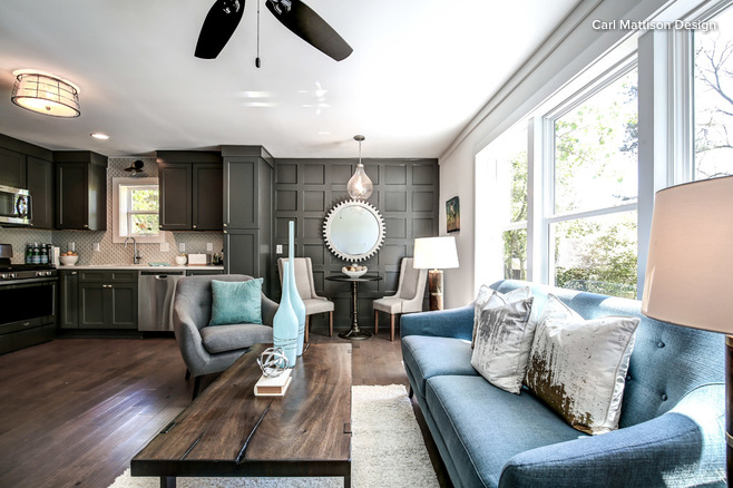 Blue sofa on right with large wood cocktail table in studio apartment