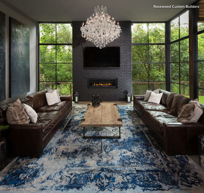 Large living room with floor to ceiling windows and two leather sofas across from each other