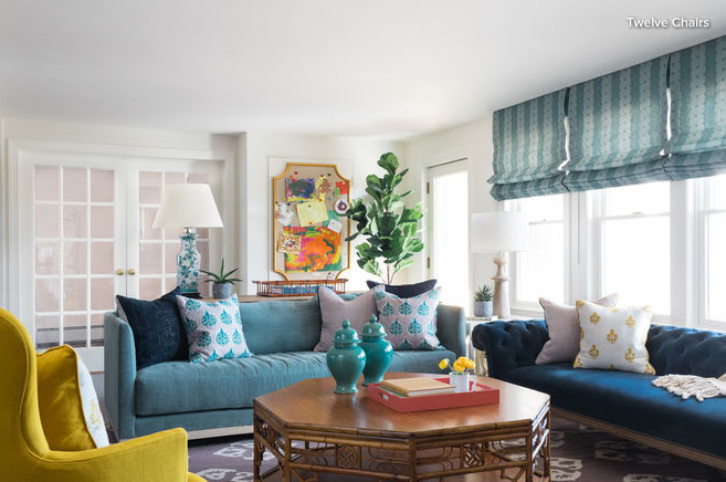 Yellow chair on left with teal sofa and blue sofa around coffee table
