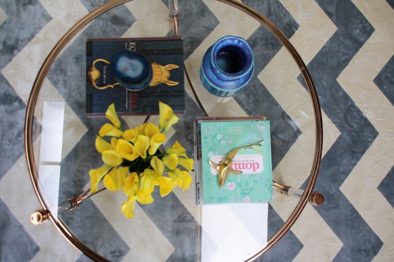 Glass coffee table on herring-bone patterned floor. 