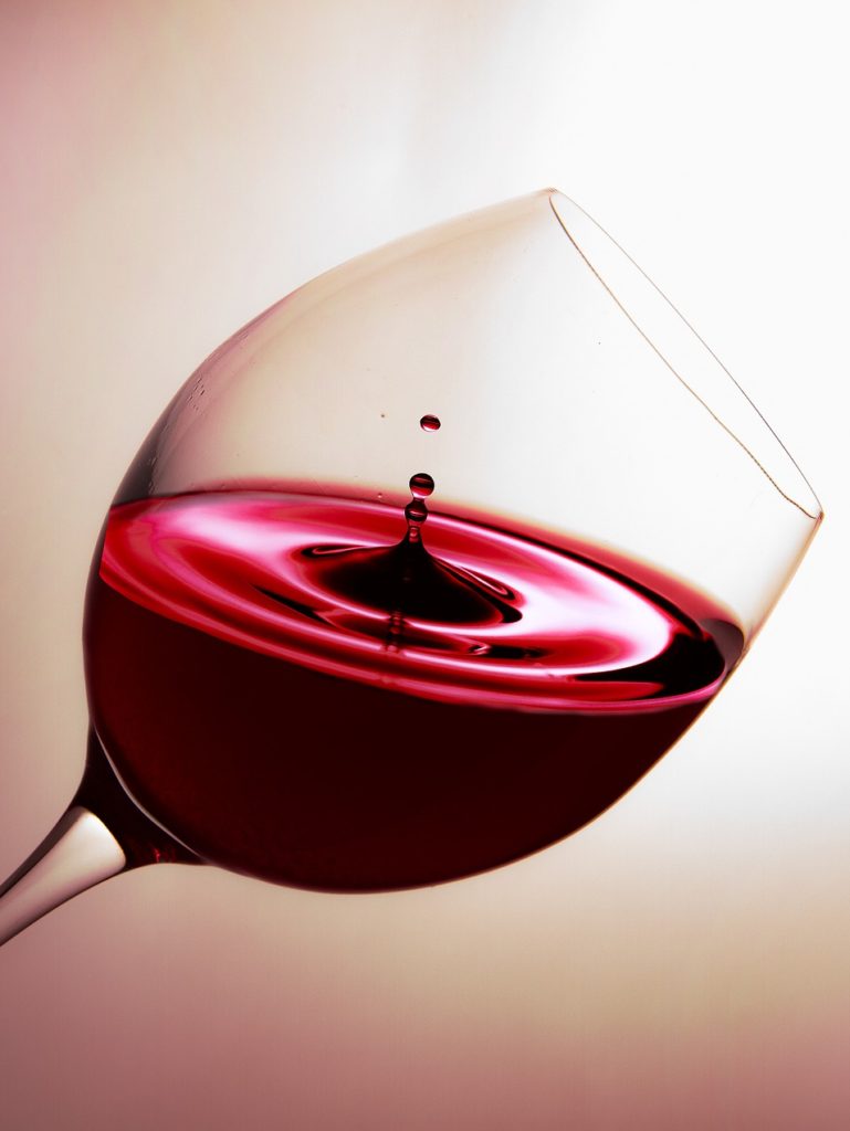 glass of wine on mauve background