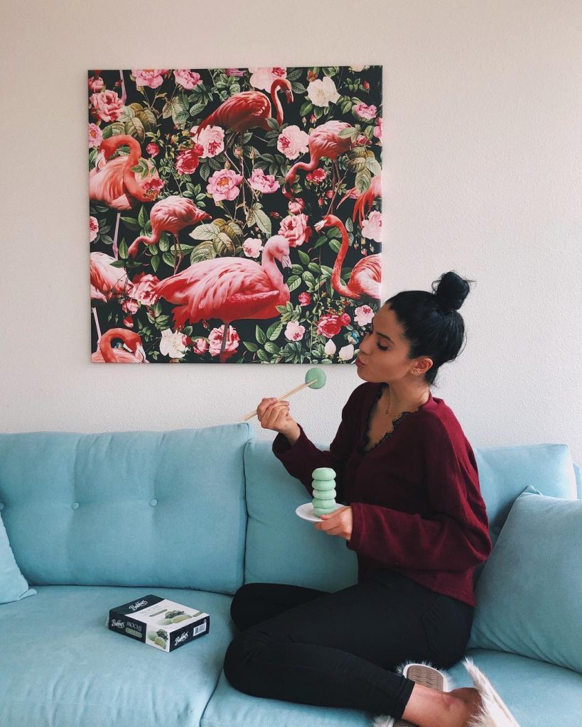 woman on blue sofa with a flamingo painting