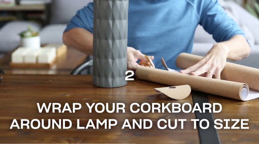 Man seated at a wooden table cutting cork sheets