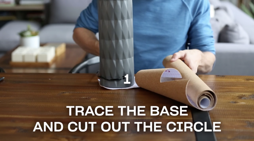 Man adding cork paper to a table lamp base