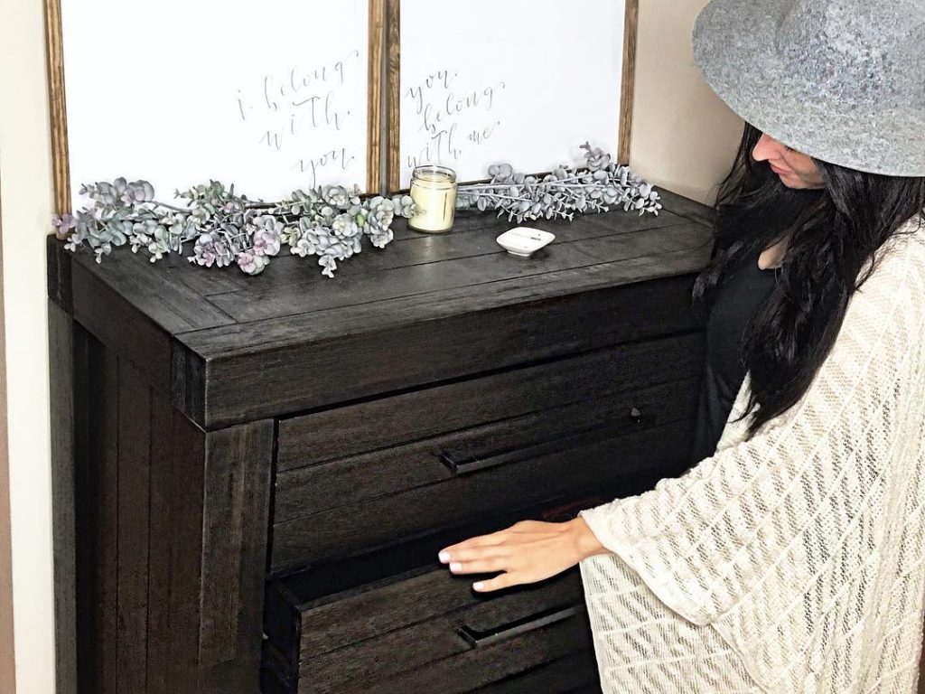 woman touching a black dresser