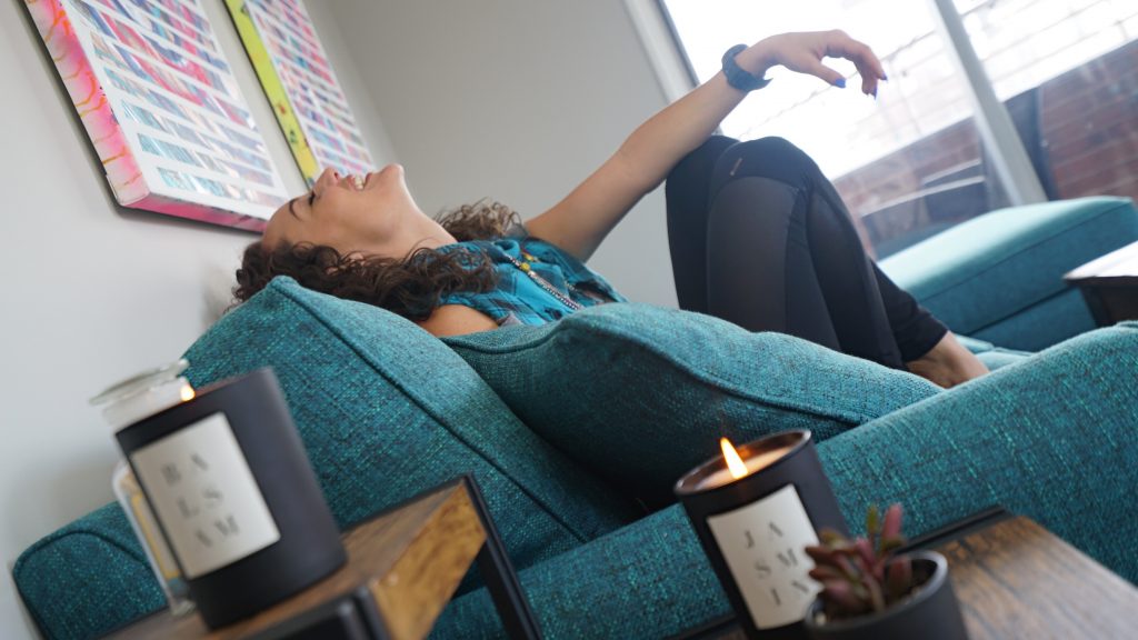 woman on blue sofa laughing