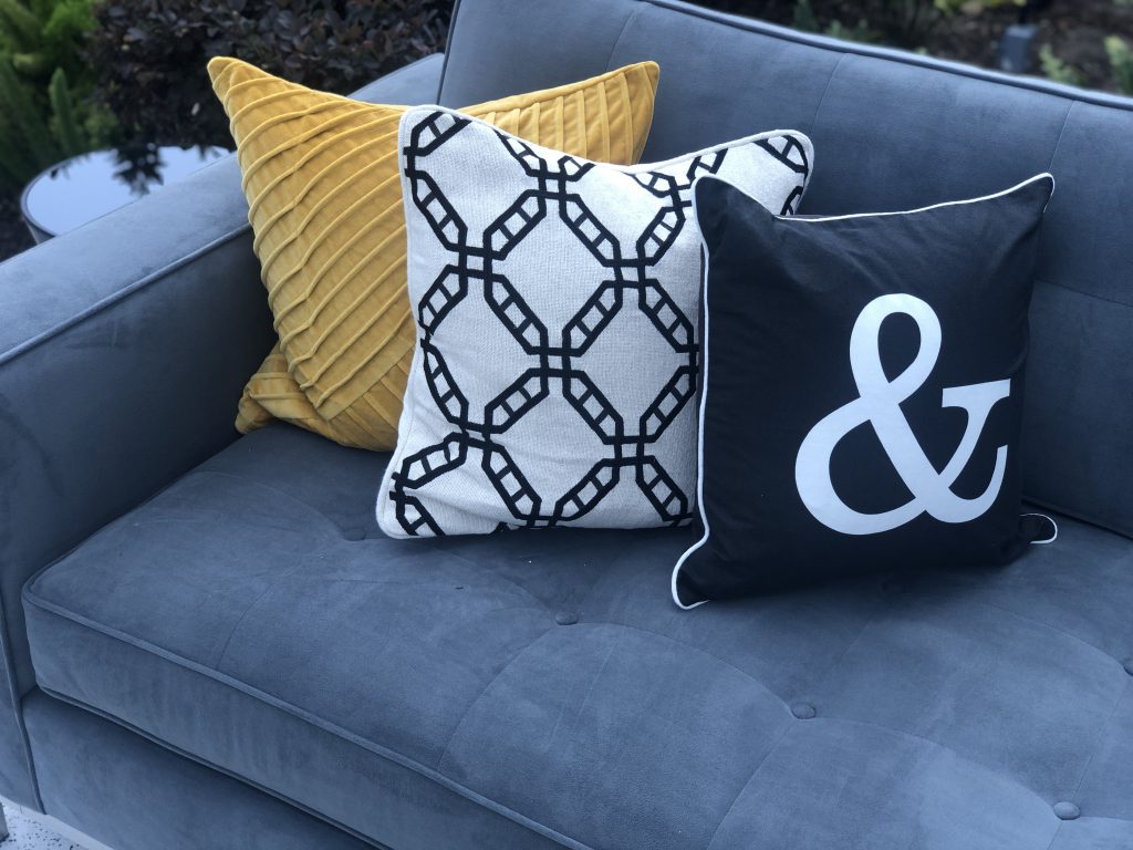 blue sofa with yellow, white and black pillows