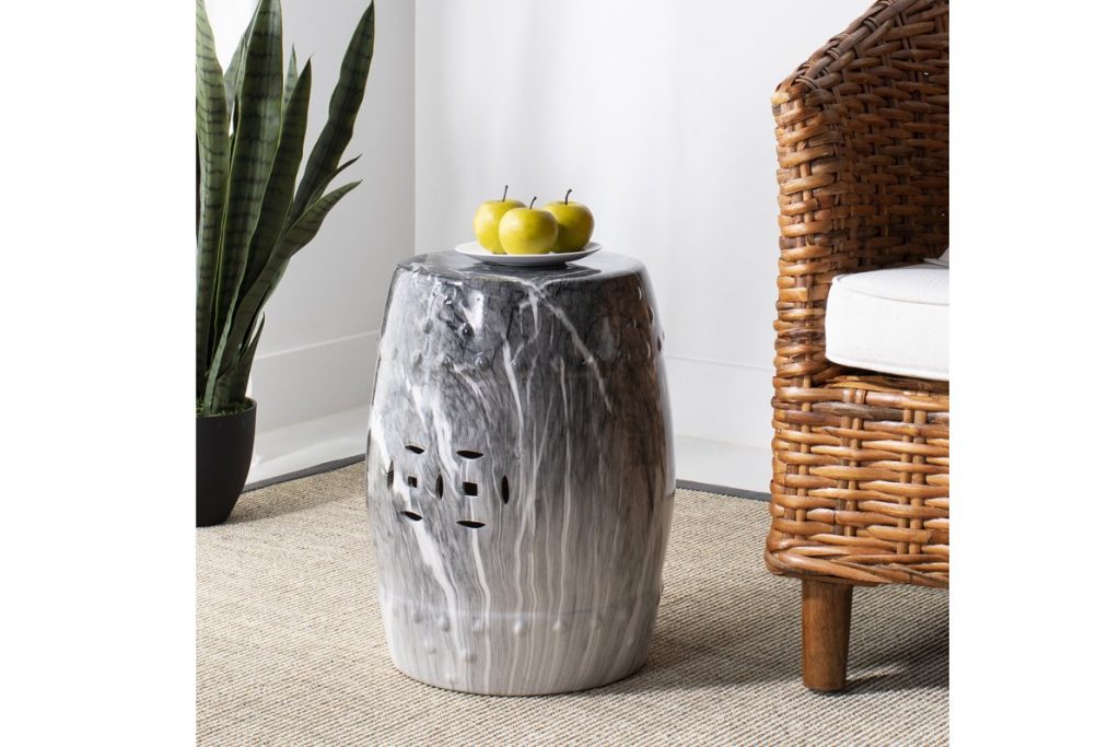 grey side table with fruit next to a wicker chair and plant