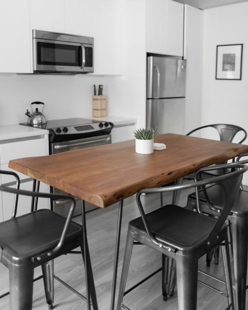 wooden dining table with black chairs in a kitchen