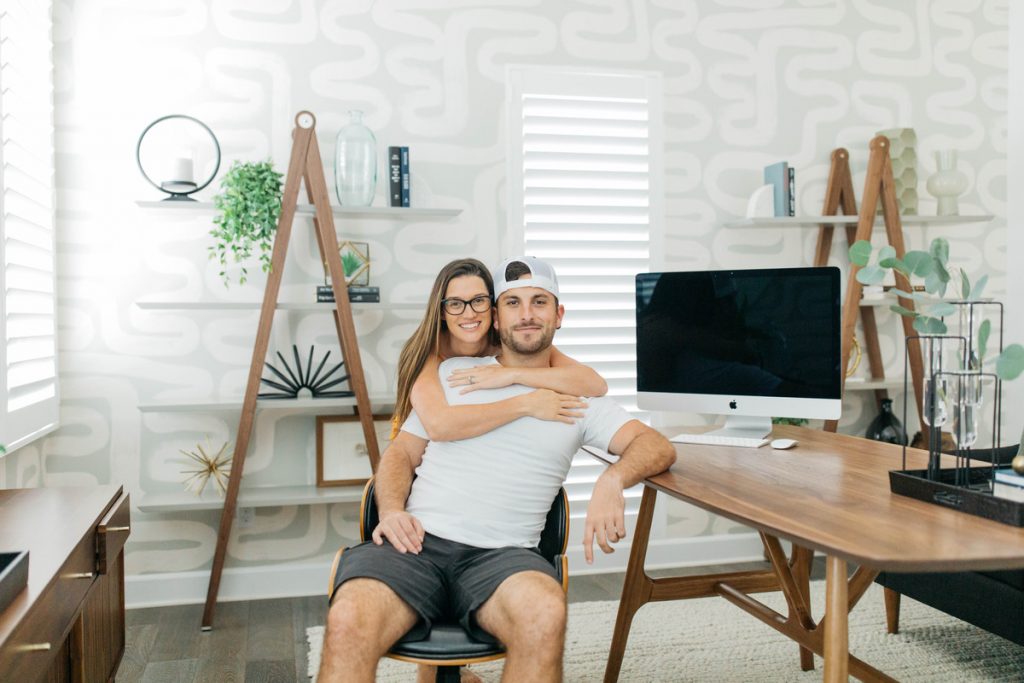 woman hugging man in a room with a laptop and wall art