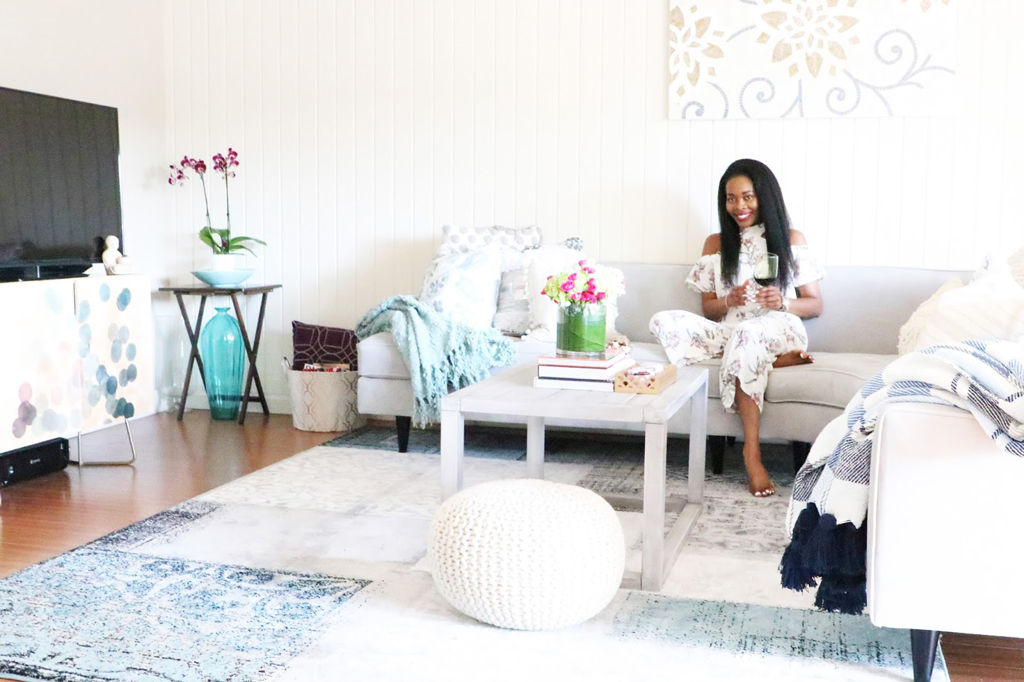 woman sitting on a white sofa with multiple blankets