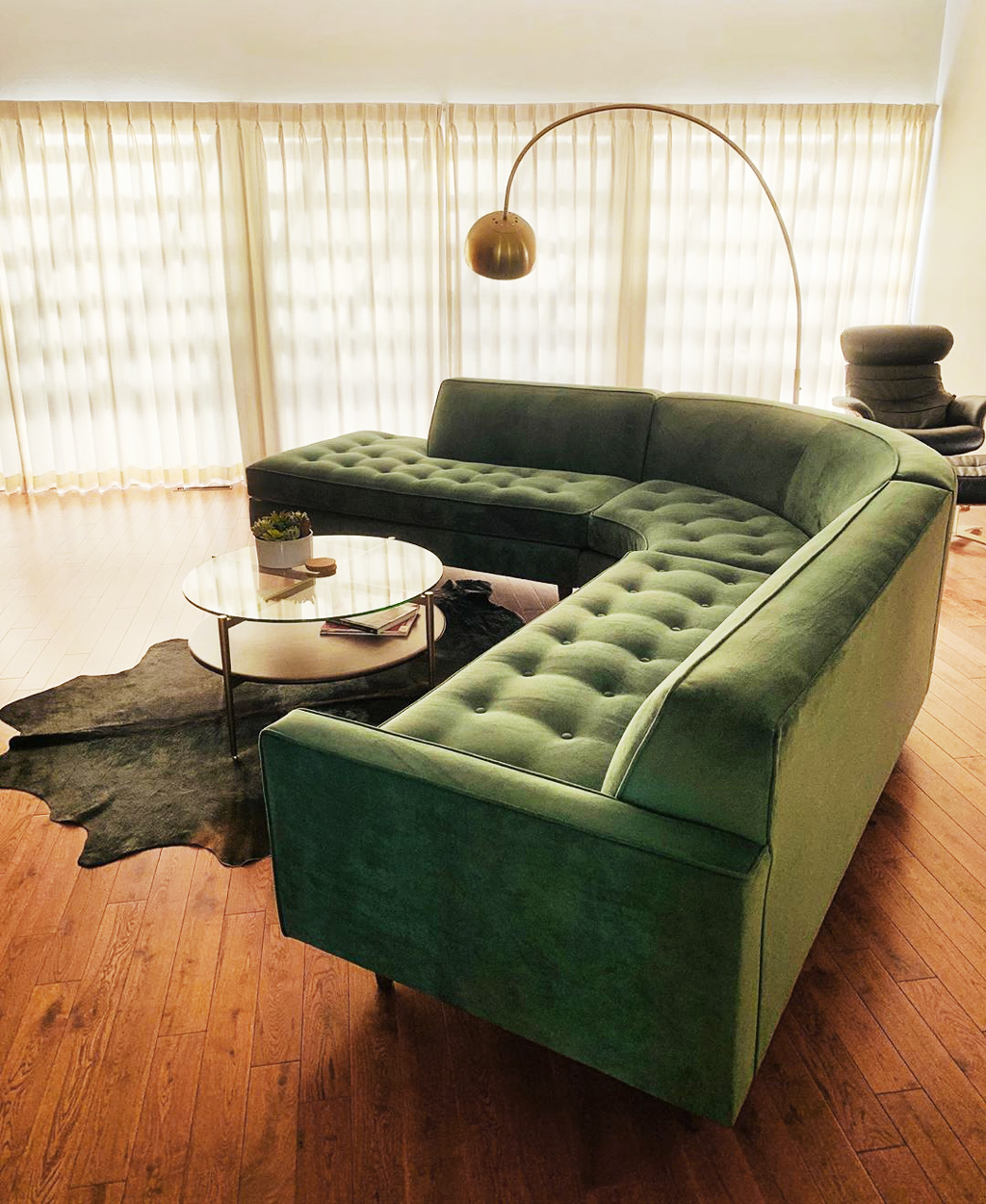 green sofa with a table, lamp and chair next to it