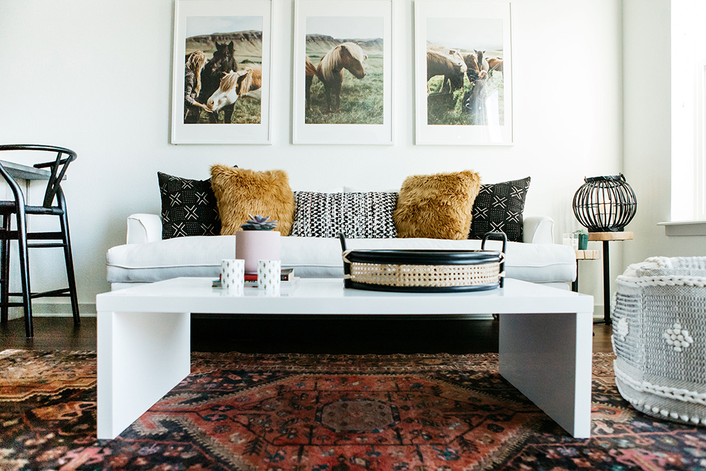 white sofa with pillows on it next to a white coffee table