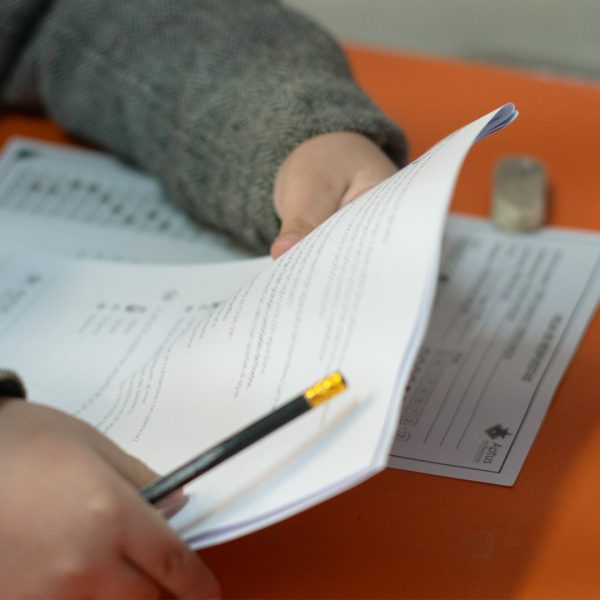 Manos de un estudiante toma una prueba que va a realizar, este también tienen en sus manos un lápiz