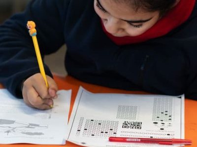 Estudiante realiza alguna prueba académica, sostiene un lápiz en su mano para responderla