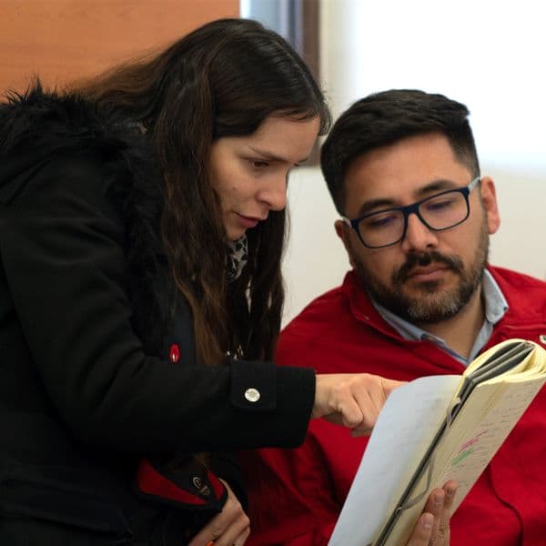 Mujer y hombre comenta algún libro o informe que uno de ellos tiene en su mano