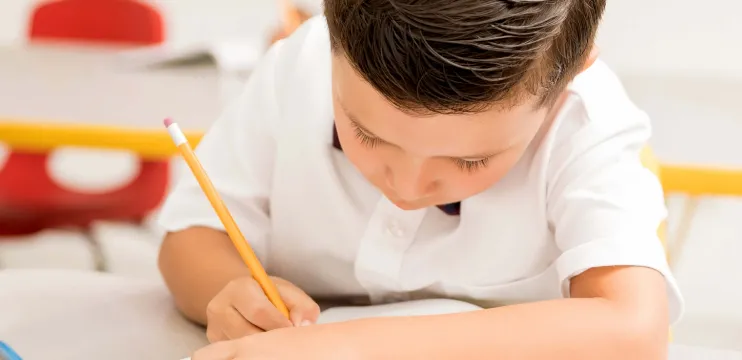 Estudiante concentrado realiza su prueba en el aula de clases