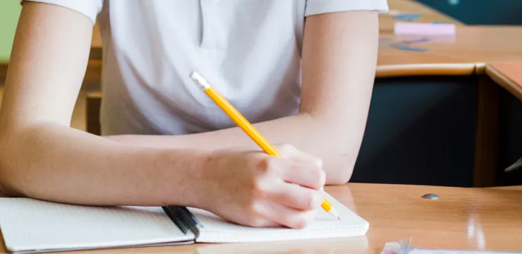 Mano de un estudiante toma nota de su clase en su cuaderno