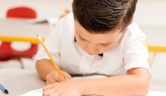 Niño aparentemente concentrado realizar una prueba en su colegio