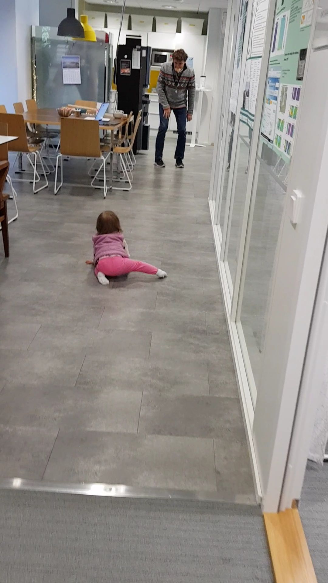 scientist with bread in his mouth playing with baby crawling on the floor