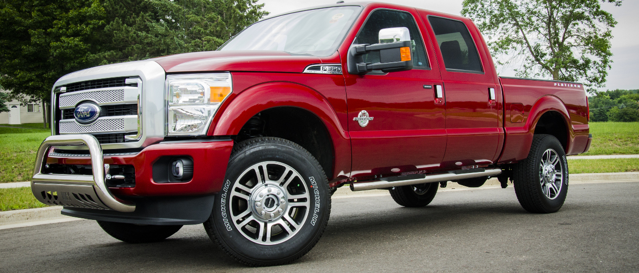 Red 2016 Ford F350 Super Duty with ARIES 4-inch oval side bars and bull bar