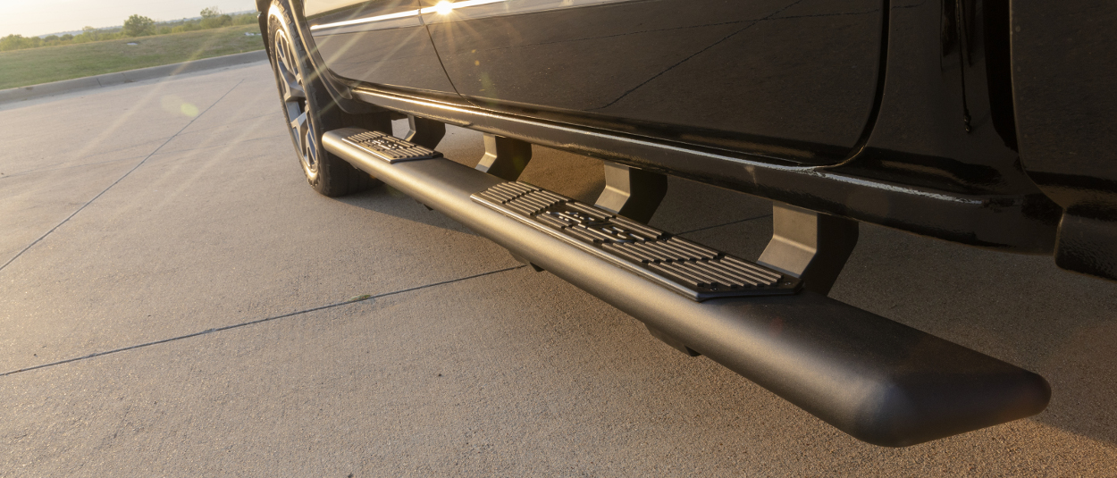 ARIES AscentStep® running boards on black truck - sunset