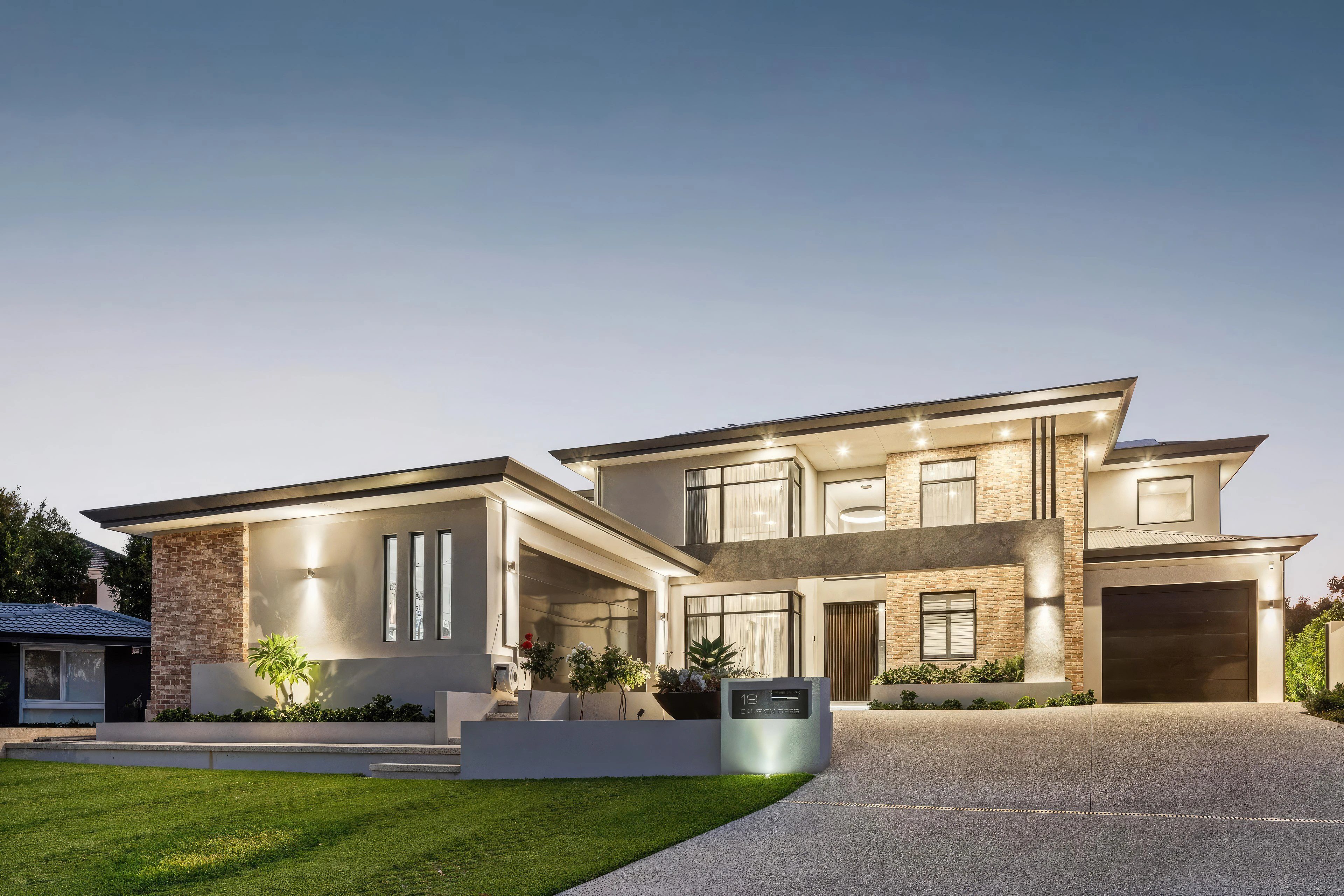 Modern two-storey house with brick and stucco exterior and landscaped front yard