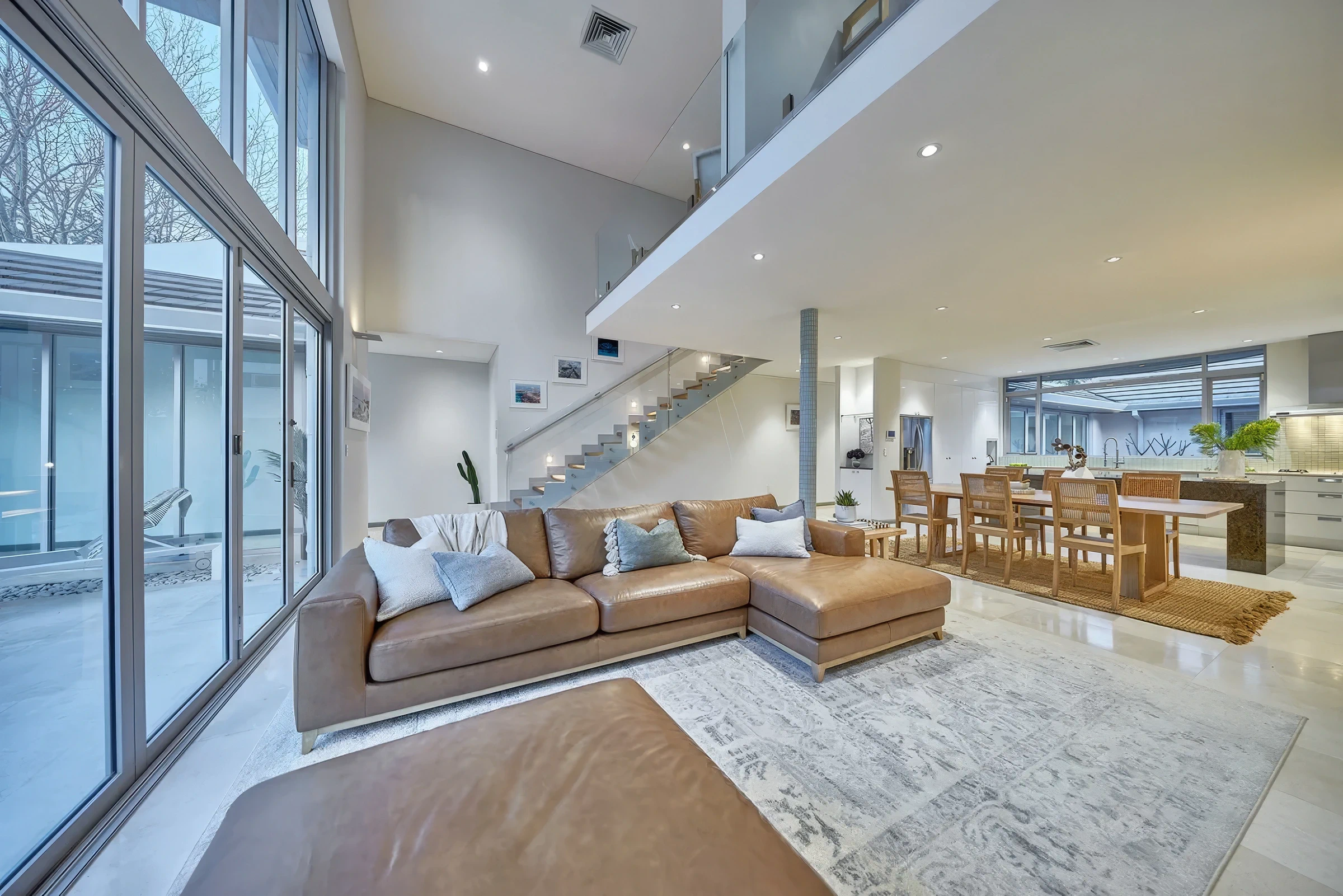 Open-plan living and dining area with large windows and modern interior.