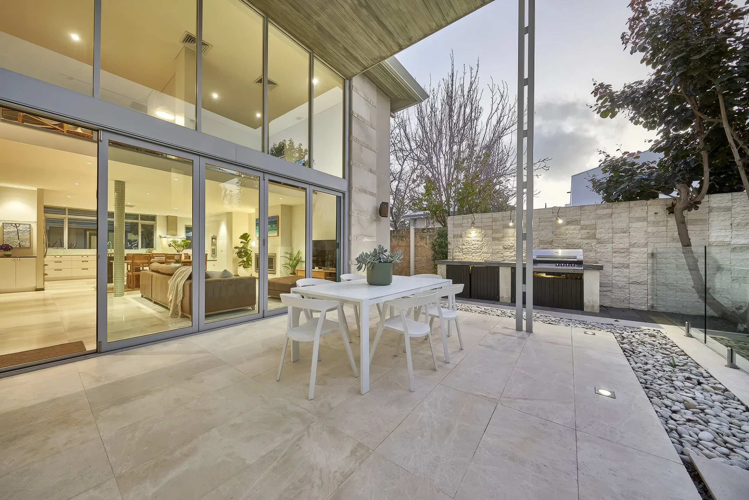 Outdoor patio with built-in outdoor kitchen and sliding glass doors leading to indoor living space