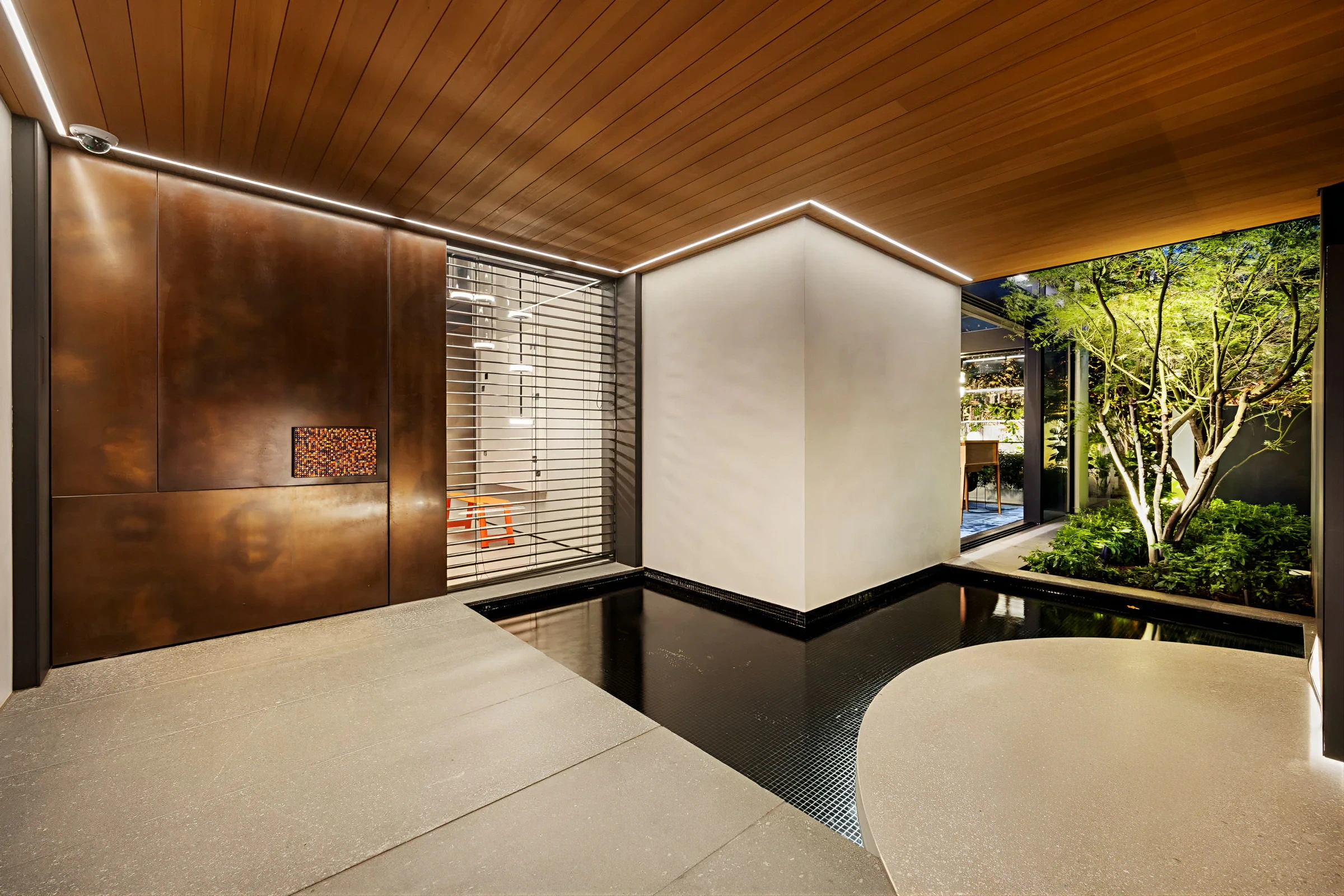 Welcoming entryway with wood ceiling, pond, and garden view