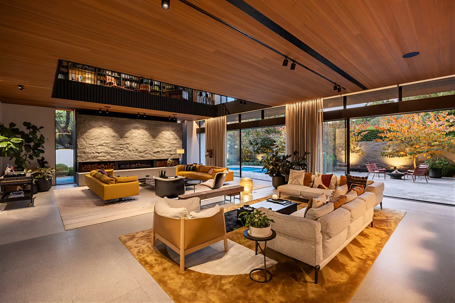 Modern open-plan living room with floor-to-ceiling windows and outdoor views