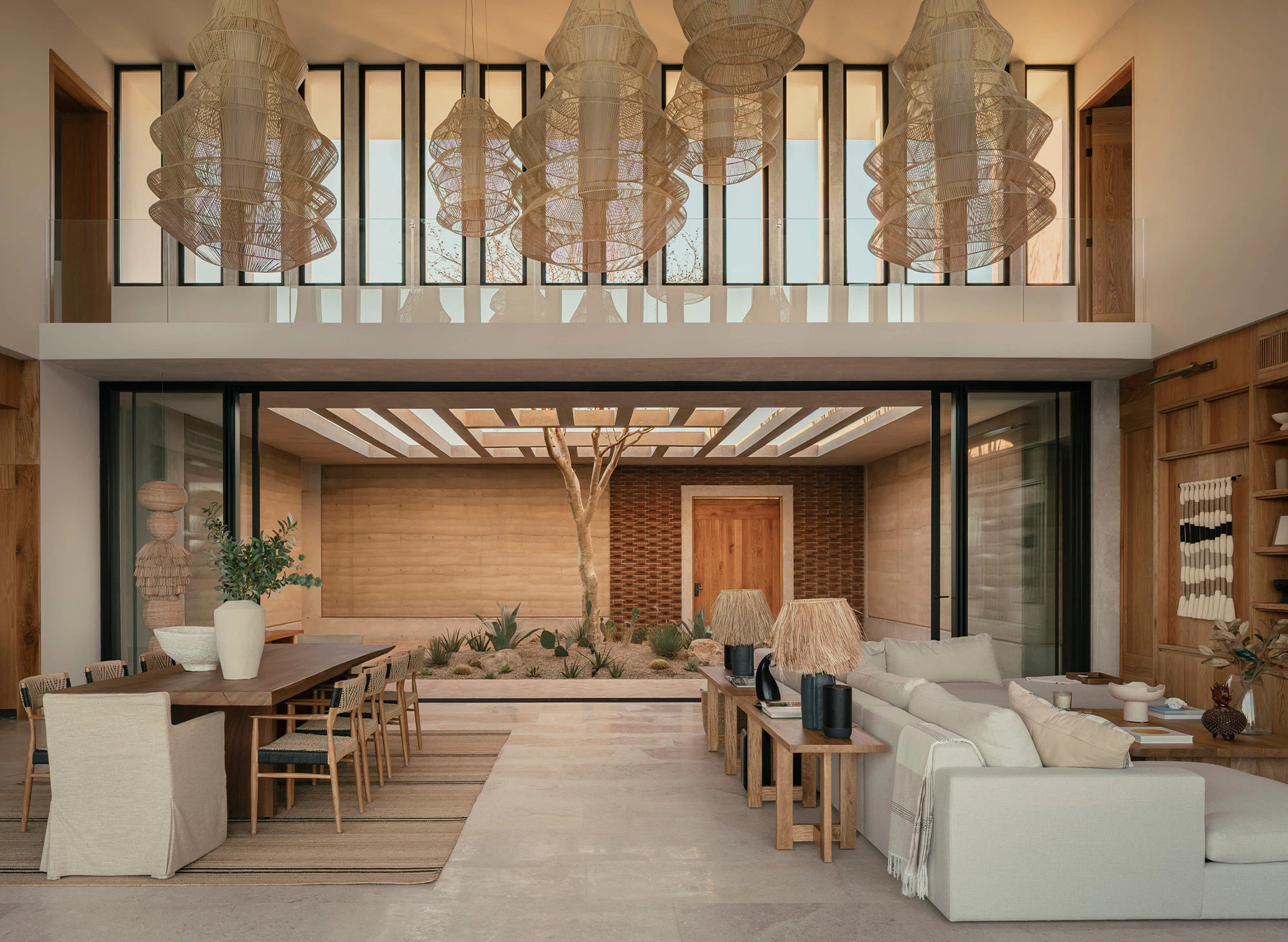 Open-plan living and dining area with indoor garden, featuring wood accents, modern lighting, and natural decor elements