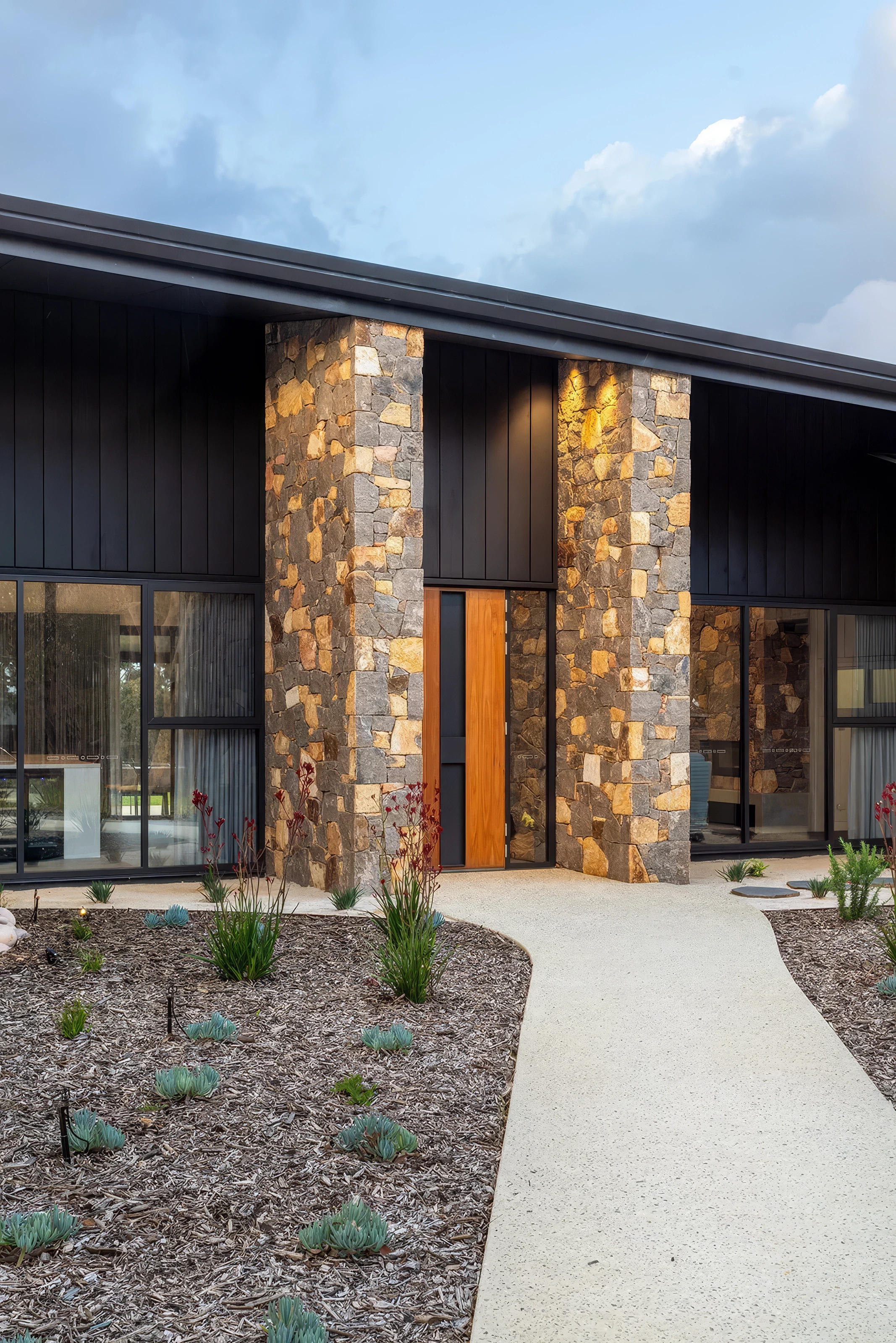 Stone facade house entrance and native Australian garden
