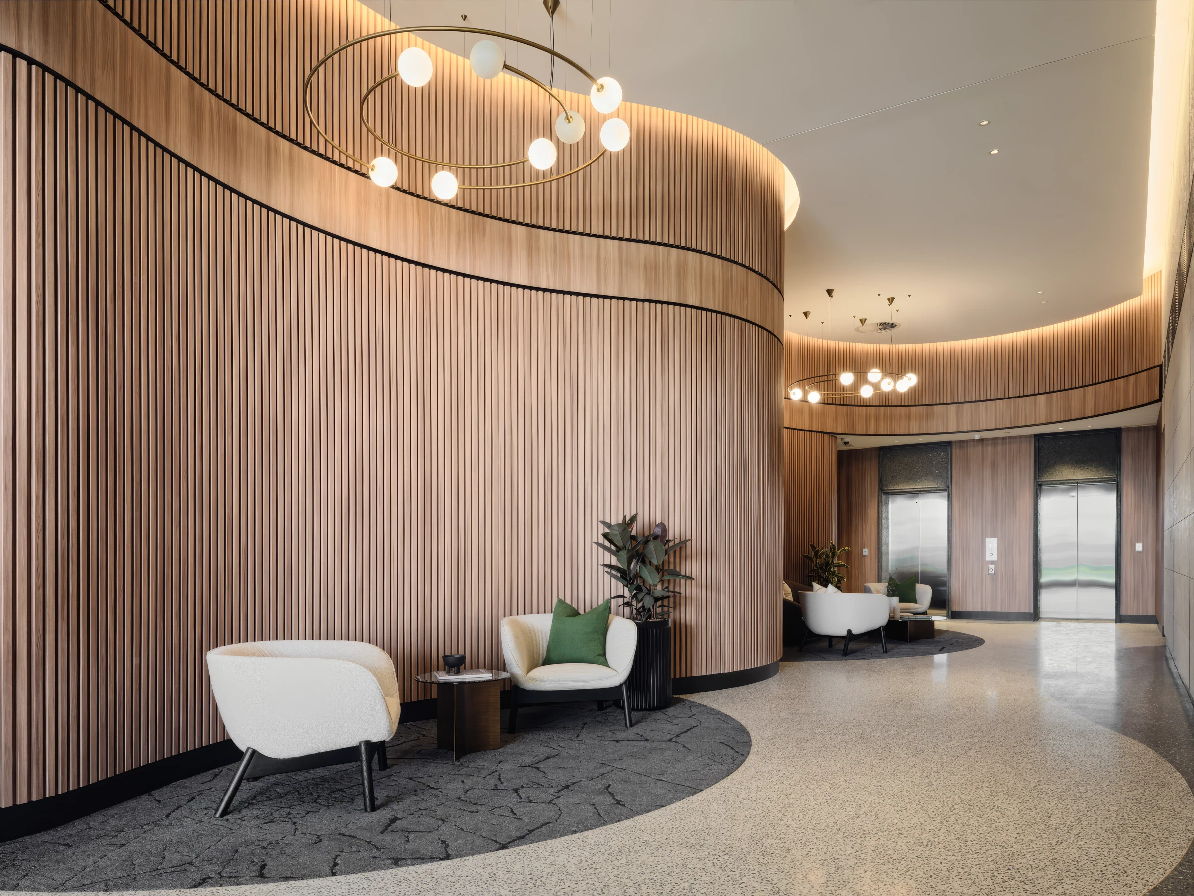 Rivière Residences lobby featuring curved timber walls and lounge seating