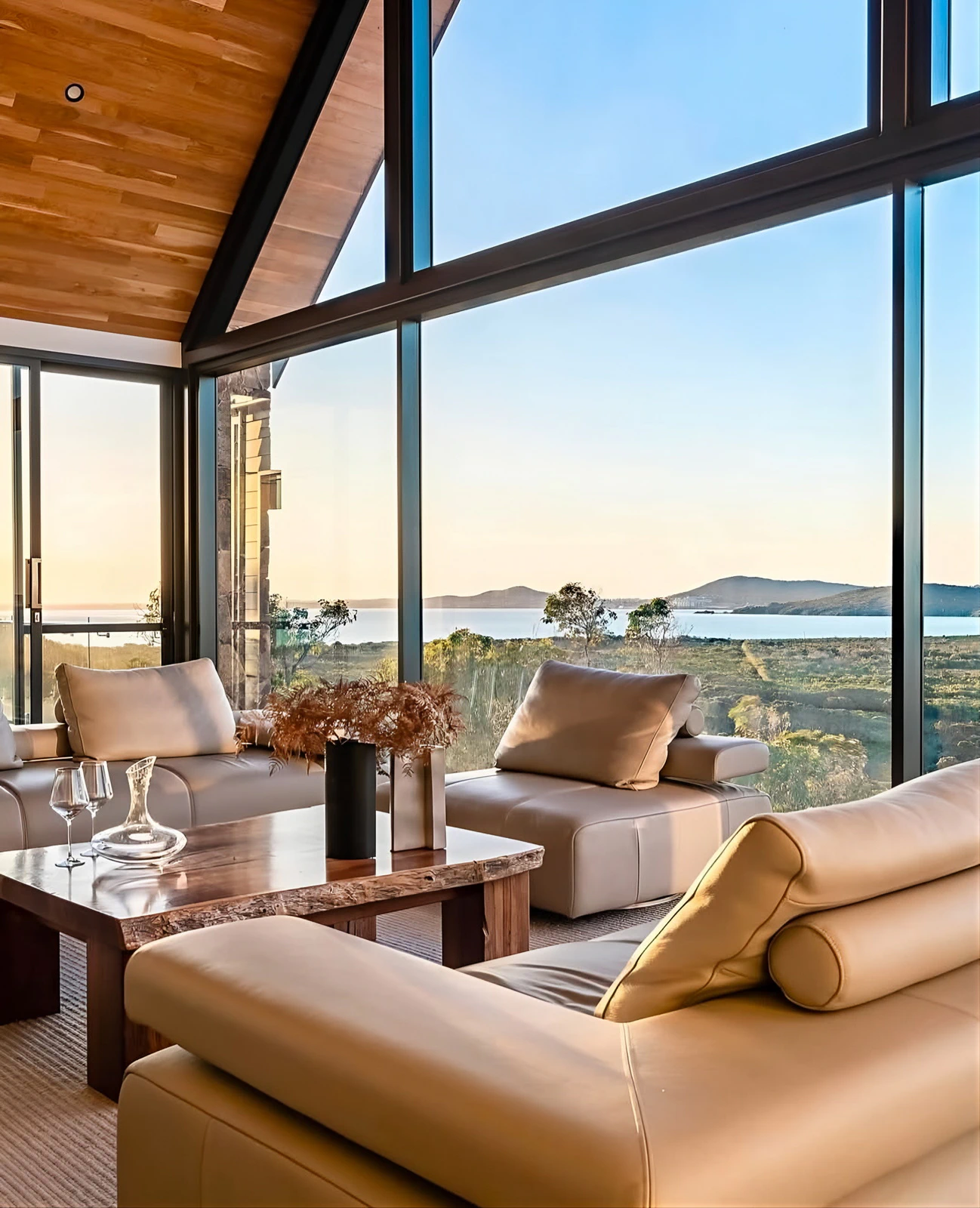 Interior seating area overlooking coastal landscape through large windows